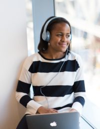Woman wearing headphones looking out a window