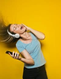 woman waving her hair in the air while listening to music through headphones