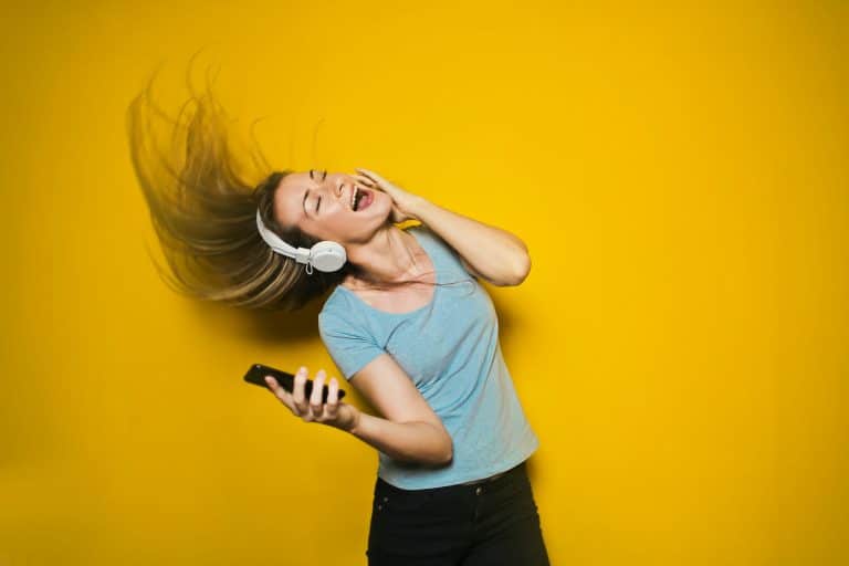 Is Your Technology Damaging Your Hearing woman waving her hair in the air while listening to music through headphones