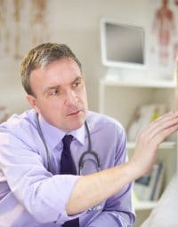 senior patient at the doctor's office gets her ears checked