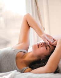 Woman in bed struggling to sleep.