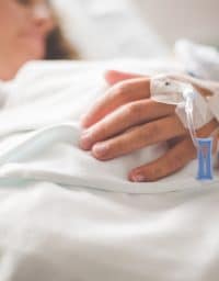 Woman in hospital receiving IV treatment.