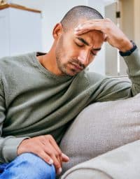 a young man puts his head in his hands