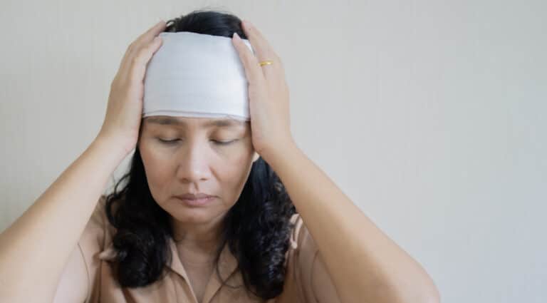Head Injury Woman with a head injury holding her head