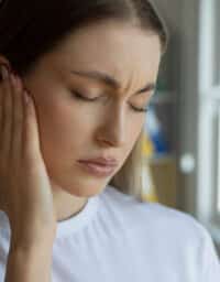 Woman with tinnitus and strong ear pain