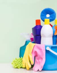 House cleaning products on table with green background