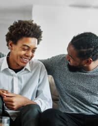 Father patting his teenage son on the back.