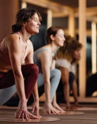 Energetic Yoga Class In Studio With Group Of Women Practicing Balance And Focus