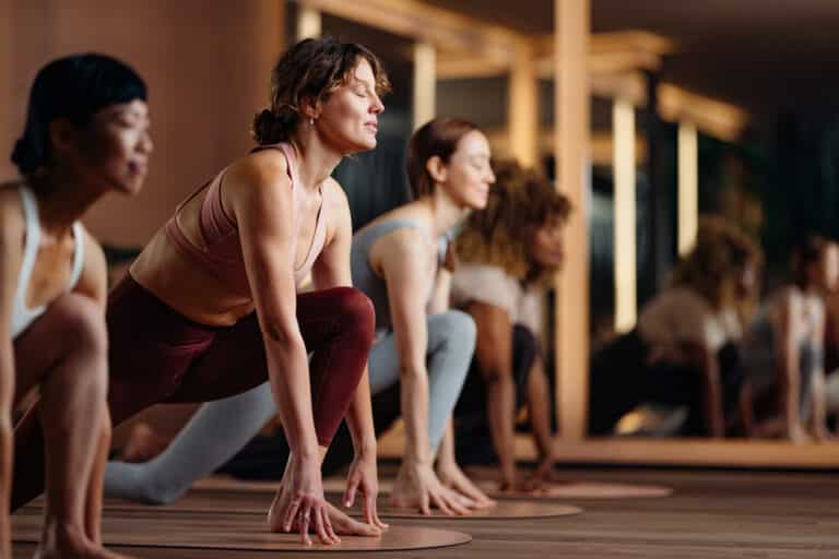Energetic Yoga Class In Studio With Group Of Women Practicing Balance And Focus