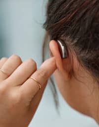 Hearing aid, closeup and ear of woman with hearing loss.