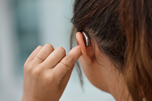 Hearing aid, closeup and ear of woman with hearing loss.